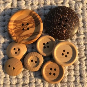 Colección de botones de madera natural de diferentes tipos (olivo, coco, madera clara) sobre tela de lana. Botones ecológicos para ropa y manualidades.