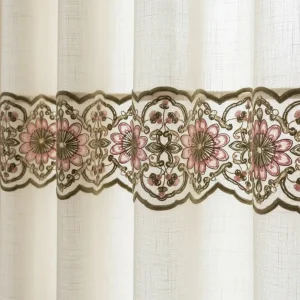 Cenefa bordada con diseño floral en hilos de seda sobre el borde de una cortina de lino crema. Borde decorativo para textiles del hogar.