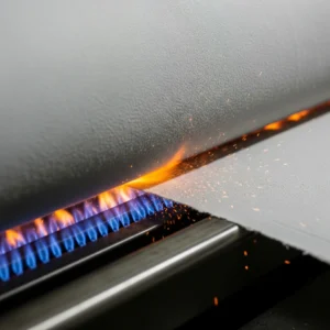 Proceso de gaseado (singeing) de una tela de algodón, donde llamas eliminan las fibras sueltas para un acabado liso. Técnica de despedir en textiles.