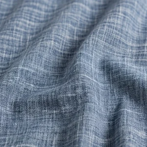Macro de tejido chambray de algodón azul, mostrando su efecto de color jaspeado y textura suave. Tela ligera para camisas y vestidos.