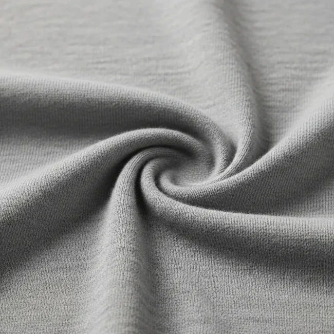 Macro de tejido combinado de polialgodón gris jaspeado, mostrando la mezcla de fibras de algodón y poliéster. Tela de mezcla para ropa.