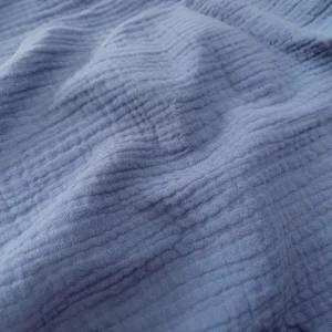 Primer plano de una tela de bambula arrugada, ligera y suave, ideal para prendas de verano.