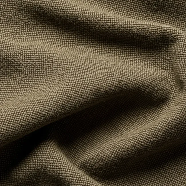 Macro de tela burda de algodón color caqui, mostrando su tejido grueso, denso y resistente. Ideal para ropa de trabajo y uniformes.