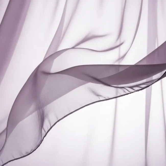 Tejido chiffon de seda lavanda pálido, ondeando suavemente, mostrando su transparencia, ligereza y caída etérea. Tela de lujo para vestidos.