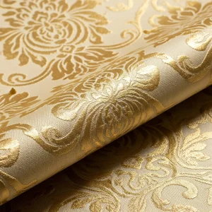 Macro de tela de Damasco dorada con patrón floral tejido en jacquard, mostrando el contraste entre superficies brillantes y mates. Tejido de lujo reversible.