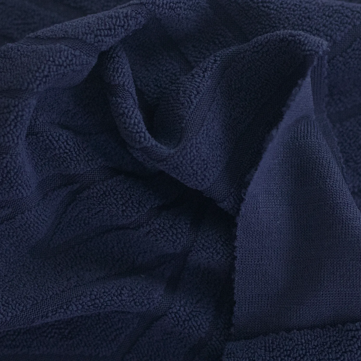 Detalle Forro Spandex Olas azul oscuro con pliegues y revés tejido. Tela elástica por metros o por mayor para fundas de sofá – Textti